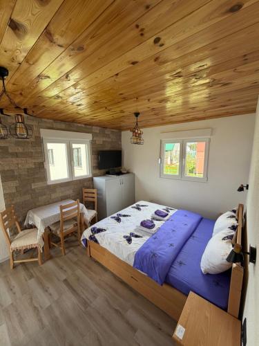 a bedroom with a large bed and a wooden ceiling at Studio Apartman Tea, Žabljak in Žabljak