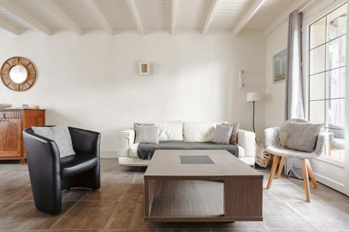 a living room with a couch and a table at Cottage Chaleureux Proche Ocean in Salles-sur-Mer