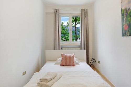 a white bedroom with a bed with a window at Apartment Gerwies in Bronzolo