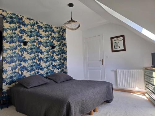 a bedroom with a bed with a floral wall at Gîte Le Cheix d'Arches in Arches