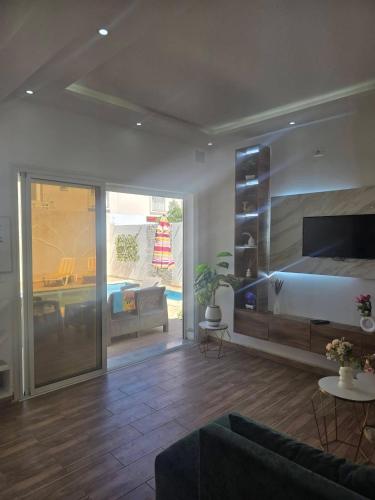 a bedroom with a bed and a living room at Villa Maya House - Cap Zbib in Banī ‘Aţāʼ
