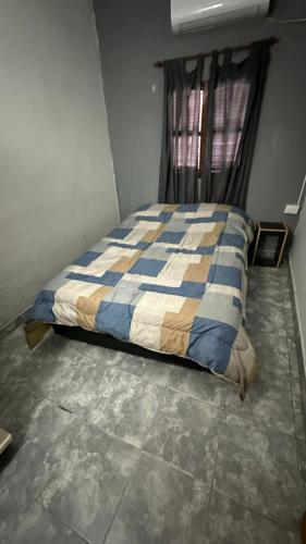 a bedroom with a bed with a blue and white comforter at Temporarios Caseros SDE in Santiago del Estero
