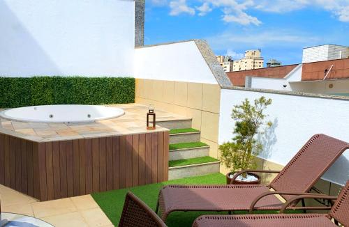 a bath tub sitting on top of a roof at Cobertura Espetacular no Belvedere com Jacuzzi in Belo Horizonte