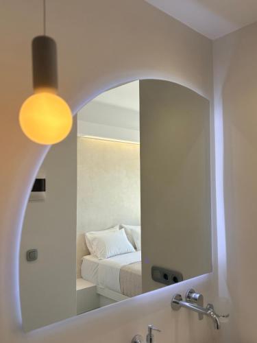 a bathroom with a mirror and a bed in a room at Hotel Faros in Ios Chora