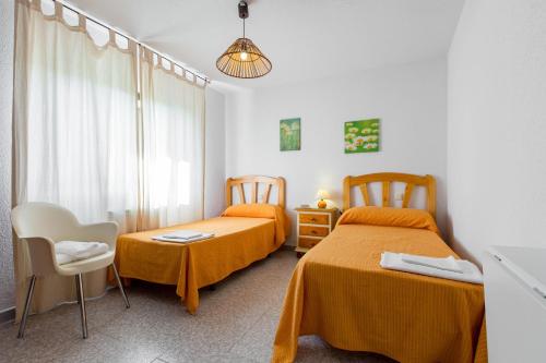 a bedroom with two beds and a table and chairs at Villa-Piedralaves-aMatalasviñas-piscina-4 viviendas in Piedralaves