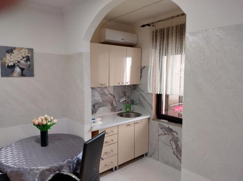 a small kitchen with a table and a sink at CaSa BOULEVARD in Brčko