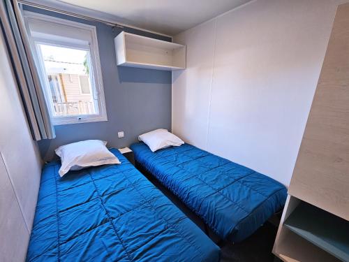 two beds in a small room with a window at VVF Labenne - Océan in Labenne
