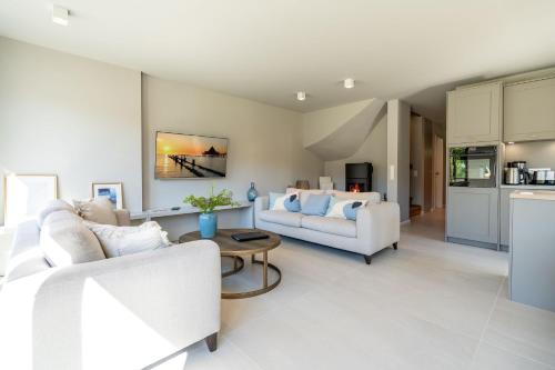 a living room with two white couches and a table at Ferienhaus Reet & Meer N 2 in Bansin