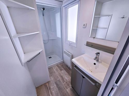 a white bathroom with a sink and a mirror at VVF Labenne - Océan in Labenne