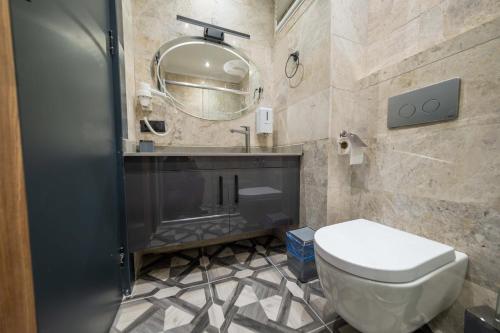 a bathroom with a toilet and a mirror at Ornella Butik Otel in Edremit