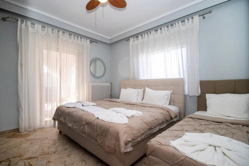 two beds sitting next to each other in a bedroom at Jonathan Central Apartment in Pefkochori