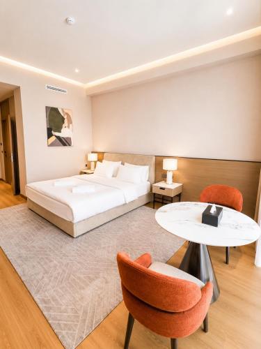 a bedroom with a bed and a table and chairs at NOMAD Luxe Hotel in Zharkent
