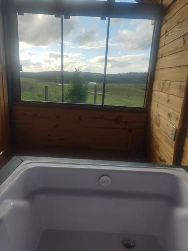 a bath tub in a room with a window at Na'raucária in Cambará