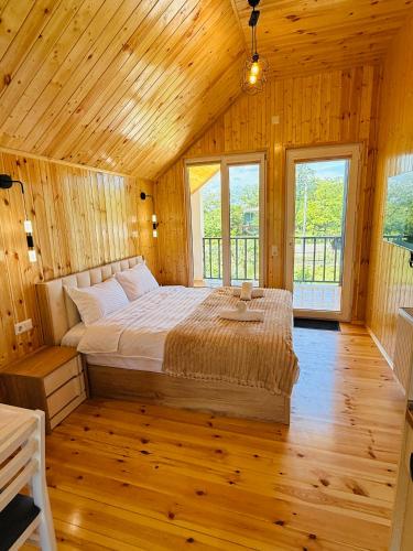 a bedroom with a bed in a wooden room at Loreta's Canyon Farmhouse in Martvili