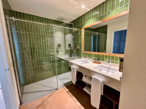 a green tiled bathroom with two sinks and a shower at Hotel Punta Bermeja Premium in El Puerto de Santa María