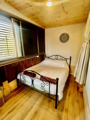 a bedroom with a bed in the corner of a room at Tzimmer B'Kfar הצימר בכפר in Kefar Pines