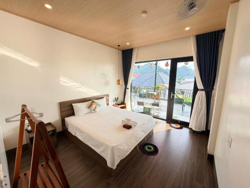 a bedroom with a bed and a large window at TuTu's Homestay Phong Nha in Phong Nha
