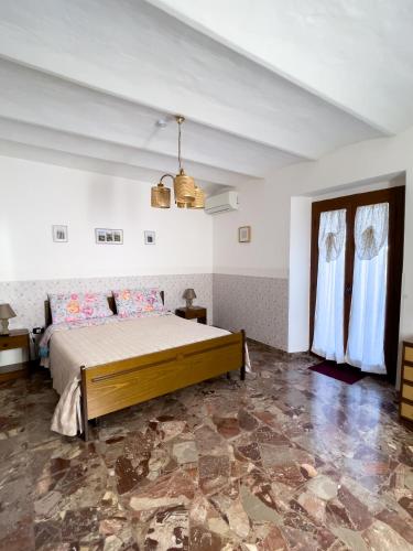 a bedroom with a bed in a white room at Flowers & Angels Home in Santa Maria degli Angeli
