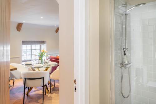 a bathroom with a shower and a table with chairs at 16 Ulph Place in Burnham Market