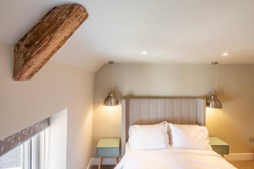 a bedroom with a bed with two lights on the ceiling at 16 Ulph Place in Burnham Market