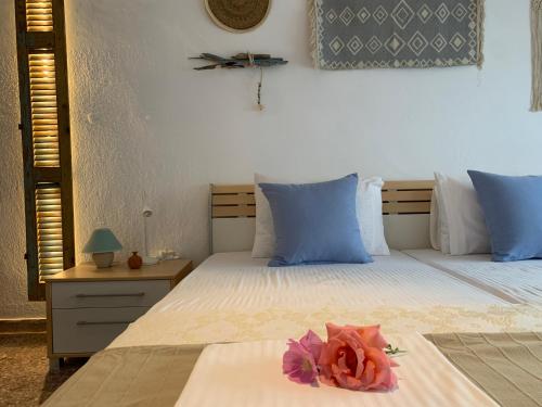 a bedroom with two beds with blue and white pillows at Kalelia in Nea Potidaea
