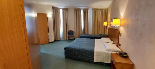 ein Hotelzimmer mit Bett, Tisch und Stühlen in der Unterkunft Classic Hotel Tulipano in Terni
