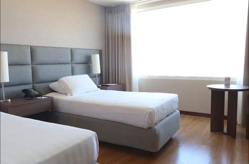 a hotel room with two beds and a window at Hotel Estelar El Cable in Manizales