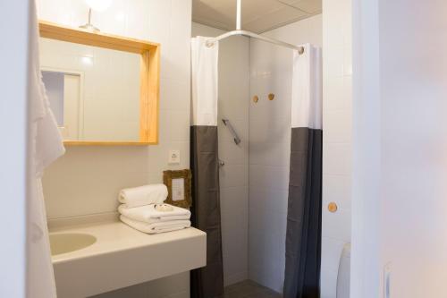 een witte badkamer met een wastafel en een douche bij Casa Julia in Delft