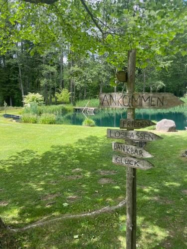 a sign in front of a park with a pond at Landhaus Wulfenia - APARTMENT KLAGENFURT - Private Sauna, Smart-TV, Air Conditioning, Free Parking in Klagenfurt