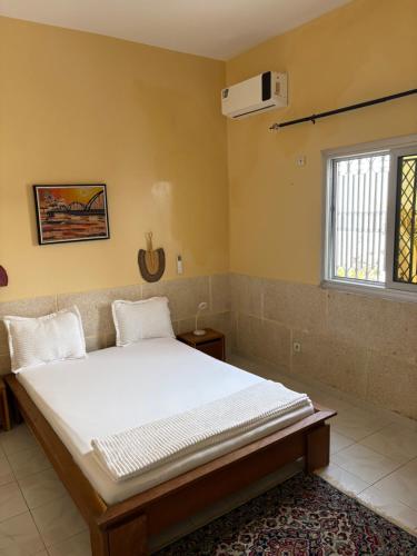 a bedroom with a bed and a window and a fan at Chez saly in Saint-Louis