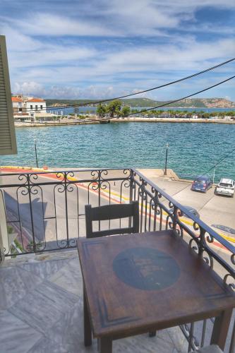 a wooden table on a balcony with a view of the water at Stella Di Mare Pylos in Pylos