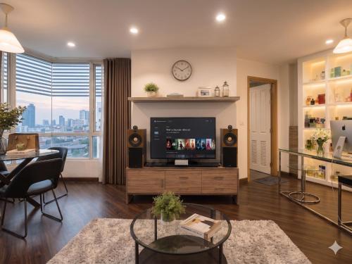 a living room with a flat screen tv and a table at The Greenway Sukhumvit 50 in Phra Khanong