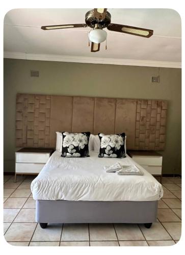 a bedroom with a bed with a ceiling fan at mission lifestyle in Empangeni
