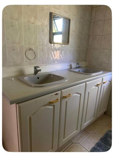 a bathroom with two sinks and a mirror at mission lifestyle in Empangeni