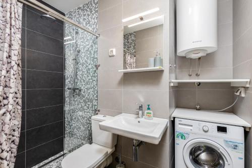 a small bathroom with a sink and a washing machine at Lavender Bay E2-1-studio apartment in Donji Morinj