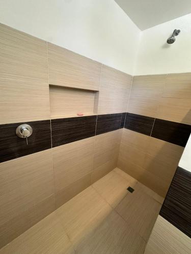 a bathroom with a shower with black and brown tile at Vista Mare Samaná in Punta Balandra