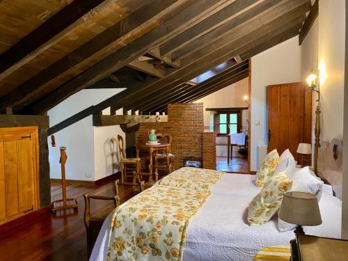 a bedroom with a large bed and a dining room at Posada la Punvieja in Los Tojos
