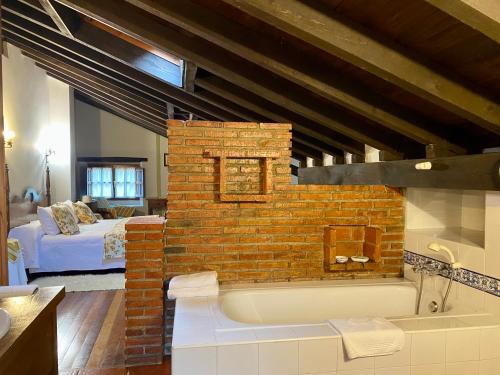 a bathroom with a brick wall and a bath tub at Posada la Punvieja in Los Tojos