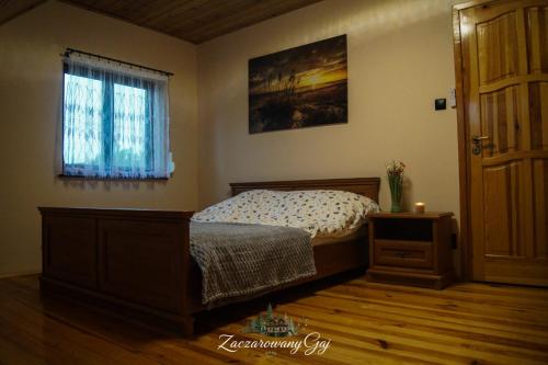 a bedroom with a bed and a window at Zaczarowany Gaj in Gaj Grzmięca