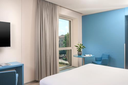 a hotel room with a bed and a window at UNA Hotels Bologna Centro in Bologna