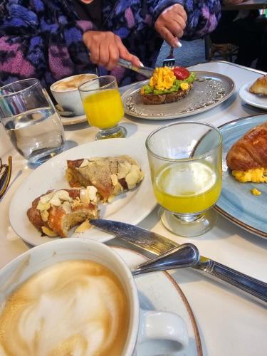 a table with plates of food and a cup of coffee at Bed&Breakfast in Maipo