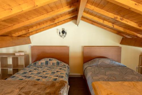 two beds in a room with wooden ceilings at Casa Fontenario in Vila Real