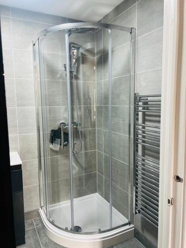 a shower with a glass door in a bathroom at Luxurious New Home Near Airport in Wythenshawe