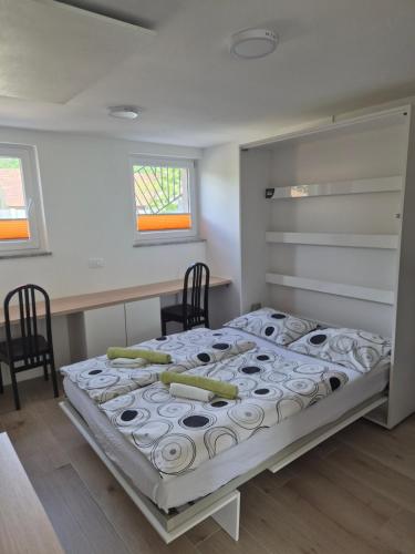 a bedroom with a bed with two chairs and a desk at Garsonjera Alina in Zgornje Gameljne