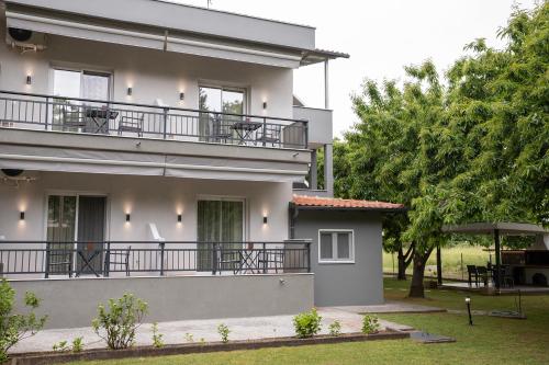 a house with a balcony and a yard at Elena luxury living in Paralía Skotínis