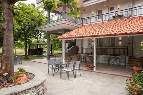 a patio with a table and chairs in front of a building at Elena luxury living in Paralía Skotínis