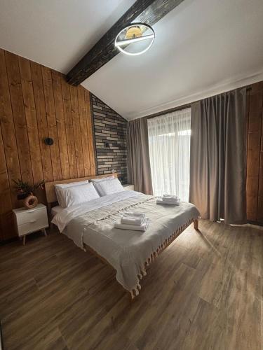 a bedroom with a large bed and a window at Sky hugs cottage in Volosyanka