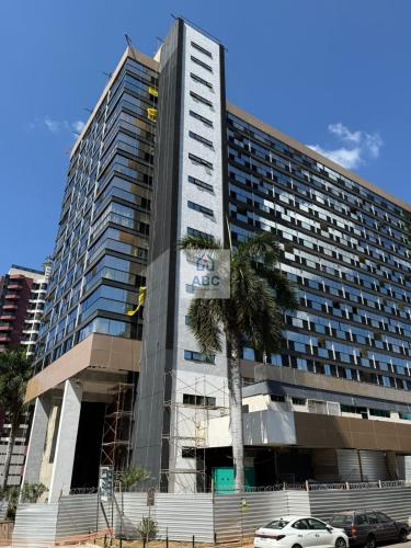 a tall building with a palm tree in front of it at ABC Apart Hotel in Brasília