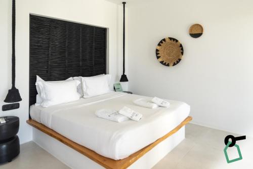 a bedroom with a white bed with towels on it at Hotiday Suites Mykonos in Mikonos
