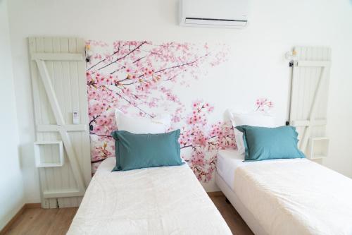 two beds in a room with a floral wall at Parnaydisiaque in Parnay